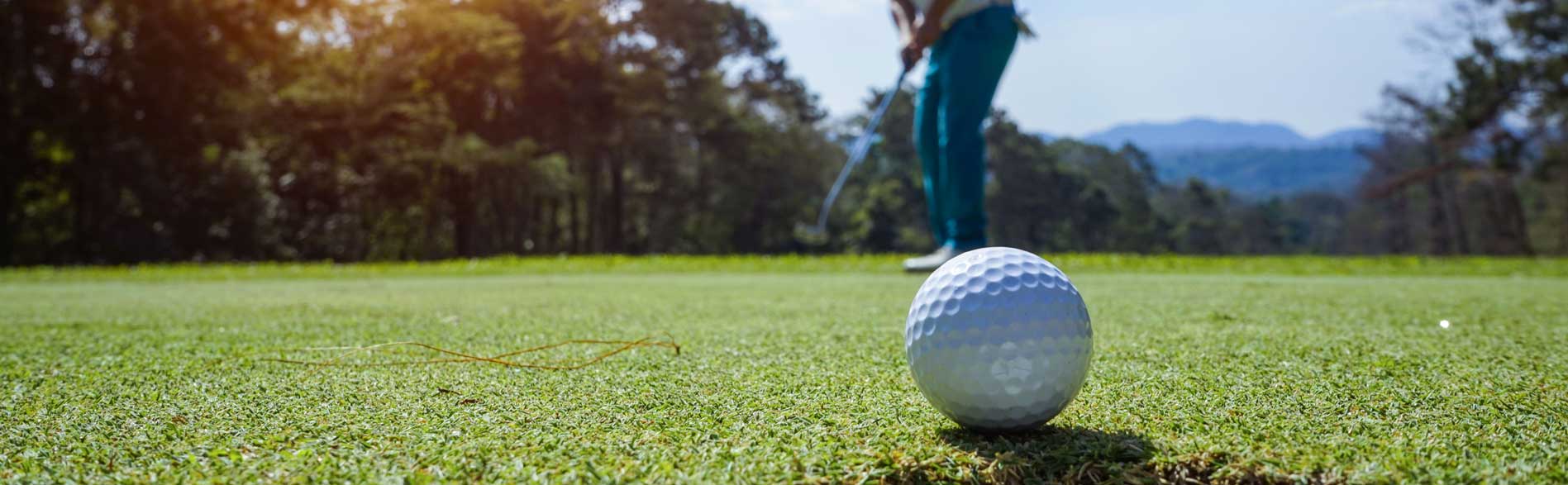 Golf ball on the putting green at sunset